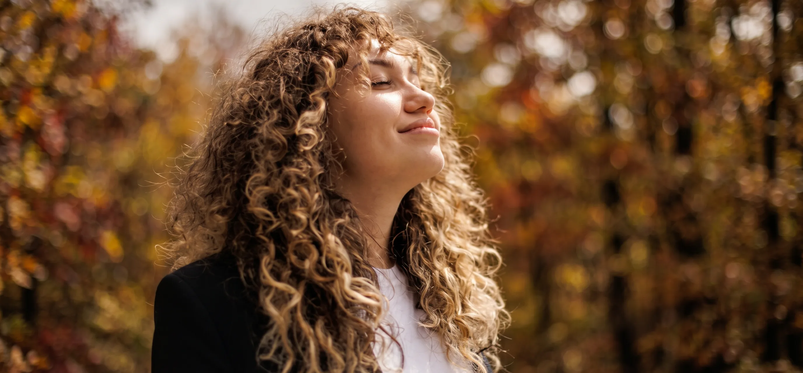 Persona sorridente in luce autunnale, simbolo della presenza In Opera sul territorio